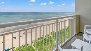 Een balkon met uitzicht op het strand en de oceaan.
