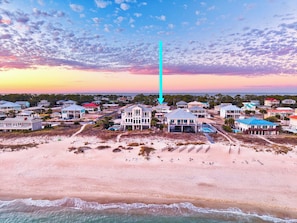 A coastal residential area with beachfront properties, a prominent vertical structure, and a clear view of the ocean.