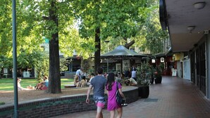 A brick pathway with a covered seating area and trees. - Contemporary 2BR Apt in Kingston (Griffith)