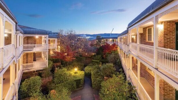 A courtyard with multiple-story buildings, each with balconies and a central pathway. - Contemporary 2BR Apt in Kingston (Griffith)