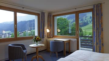 Deluxe tweepersoonskamer | Woonruimte | Een 25-inch flatscreentelevisie met kabelzenders en een computerscherm