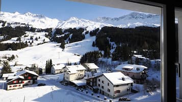 A snow-covered mountain village with traditional buildings and a ski slope.