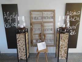 Un panel de madera con tarjetas de identificación colgando, dos jarrones de vidrio sobre pedestales, y un letrero con texto.