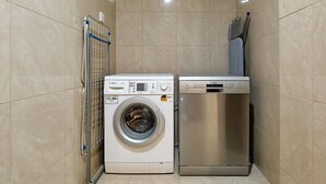 Ein kleiner Hauswirtschaftsraum mit einer Waschmaschine mit Frontlader und einem integriertem Trockner.
