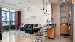 Ein modernes Wohnzimmer mit einer Couch, einem Esstisch und einer Küchenzeile.