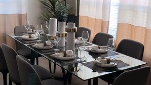 A dining area with a glass table, black chairs, and a modern chandelier. - Luxury/Modern 5Bed and 4bath Private Pool and Free Resort 10min da Disney 11ppl (Kissimmee)