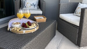 A wicker outdoor seating area with a tray of snacks and drinks, a decorative fish and ship wheel on the wall, and a cushion with "home" embroidered on it. - Luxury/Modern 5Bed and 4bath Private Pool and Free Resort 10min da Disney 11ppl (Kissimmee)