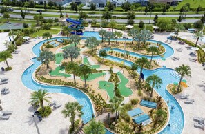 Ein Poolbereich mit mehreren Wasserrutschen, Palmen und Liegestühlen.