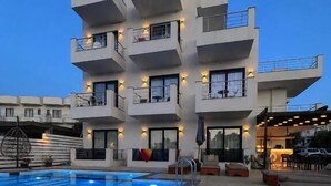 A modern hotel with a pool, outdoor seating, and a sign reading 'NOA'. - Noa Boutique Hotel (Ksamil)