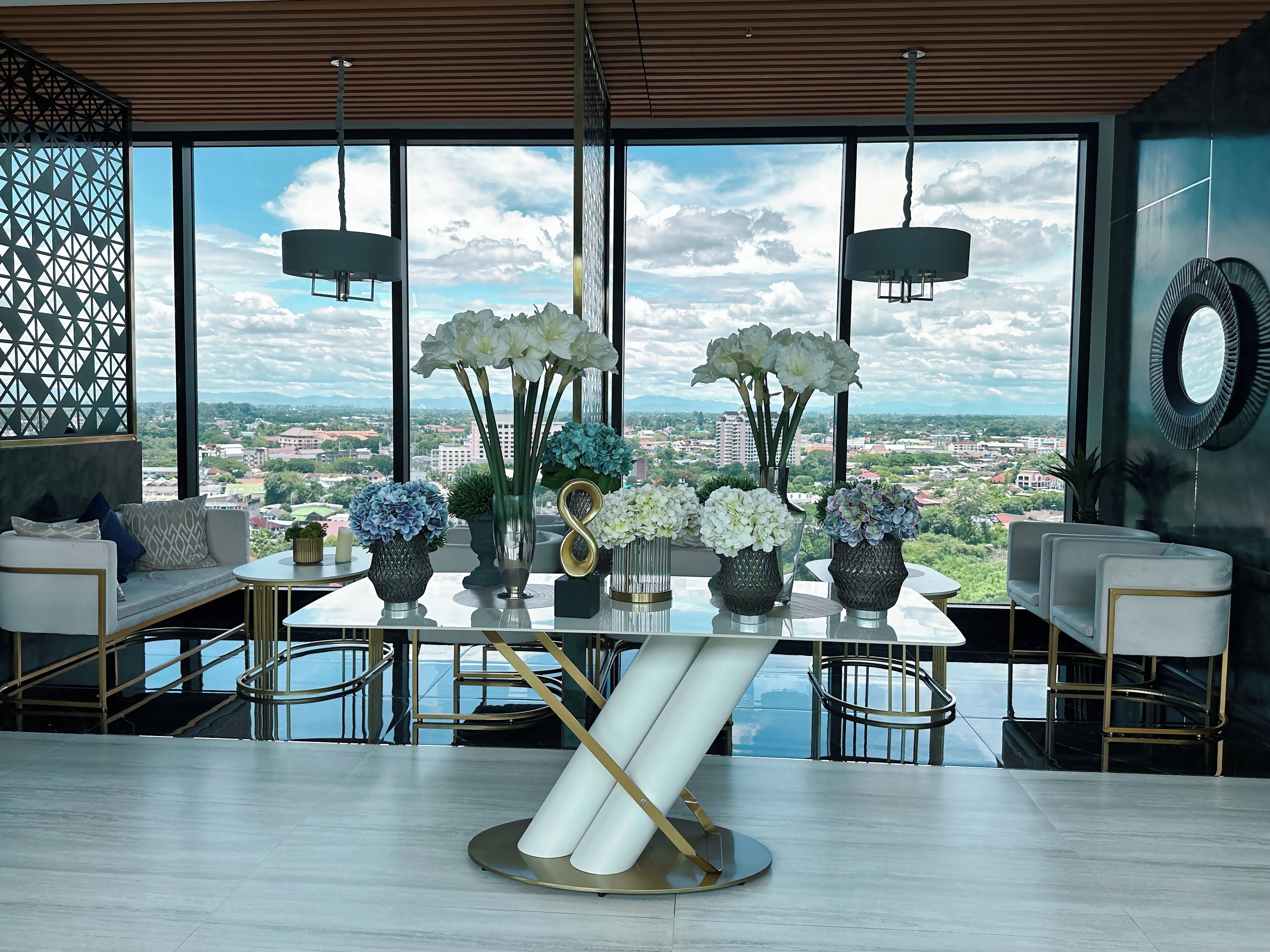 Un espace de restauration moderne, doté d’une grande table, de chaises et offrant une vue sur le paysage urbain grâce à de larges fenêtres.