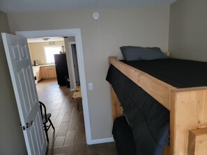 Cozy retreat with a wooden bunk bed, small table, and chair.