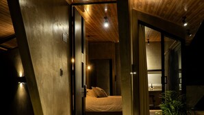 A modern interior with a bed, a potted plant, and a staircase leading to a second level. - Almazewá (Ubaque)
