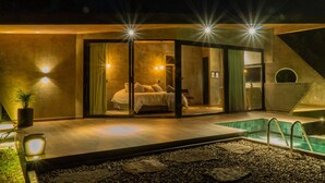 A modern bedroom with a glass door, a pool, and a small outdoor seating area. - Almazewá (Ubaque)