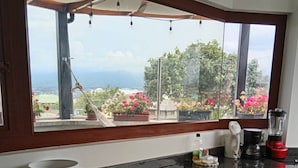 Eine moderne Küche mit großem Fenster, Einbauofen und einer Arbeitsplatte mit diversen Geräten.