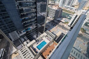 A high-rise building with a rooftop pool and multiple balconies.