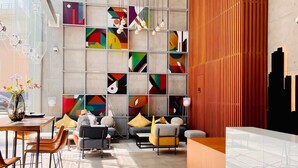 A modern reception area with a geometric wall design, a wooden panel accent, and a seating area with a sofa and chairs. - Bright 1BR sea view and balcony (Dubai)