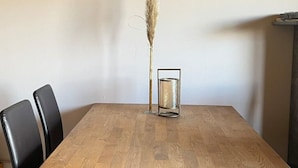 A dining table with a vase of dried pampas grass and a candle holder. - Ferienwohnung Pfalzblick (Bacharach)