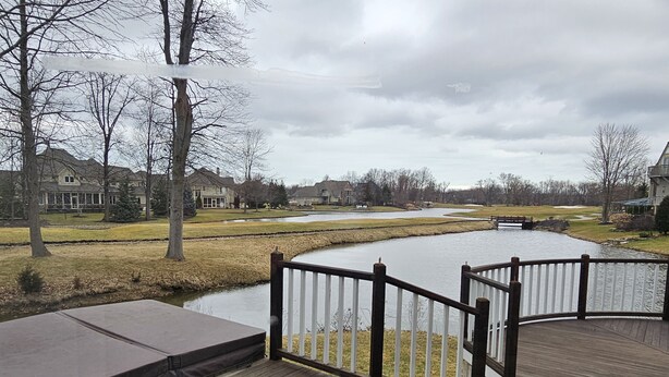 A wooden deck with a view of a river and houses in the background. - Avon Lake, Avon golf course home, 1,000 s.f. open outdoor deck on course lake (Avon)