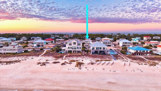 A coastal residential area with beachfront properties, a prominent vertical structure, and a clear view of the ocean.