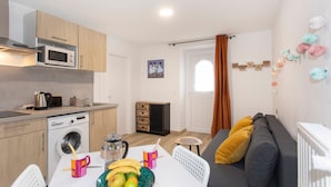 A compact living space with a kitchenette, a dining area, and a sofa.