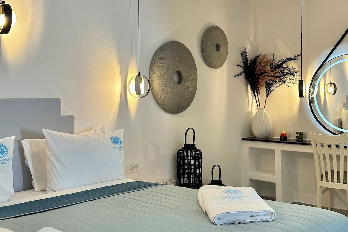 Um quarto moderno com uma cama grande, mesas de cabeceira, uma escrivaninha e uma cadeira.