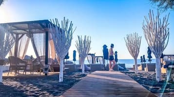 Privat strand, sort sand og strandbar