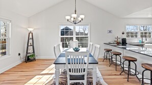 A spacious kitchen with a large island, white cabinetry, and a hanging light fixture. - BLUEBERRY COTTAGE is located in Mena.  WIFI, remodeled , Lockable bike storage ! (Mena)
