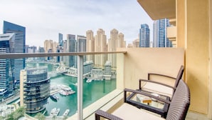 A balcony with a view of a cityscape, including high-rise buildings and a marina with boats. - The Address Dubai Marina 1BR (Dubai)