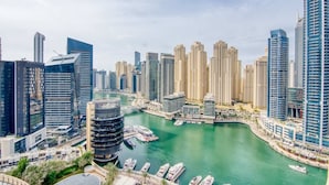 A high-rise urban area with modern architecture, a marina with boats, and a river. - The Address Dubai Marina 1BR (Dubai)