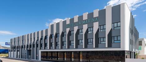 A modern hotel building with a prominent sign reading "HOTEL LA MARINA."