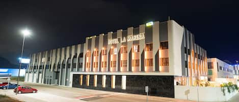A modern hotel with a prominent sign reading "HOTEL LA MARINA."