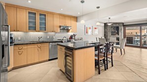 A modern kitchen with wooden cabinets, stainless steel appliances, and a central island. - North Of Nell, Unit 3j (Aspen)