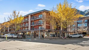 A multi-story hotel with balconies, a covered entrance, and a parking lot. - North Of Nell, Unit 3L (Aspen)