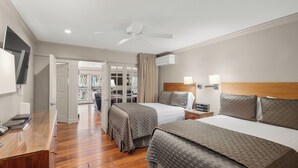 A hotel room with two beds, a ceiling fan, a TV, and a wooden desk. - North Of Nell, Unit 4e (Aspen)