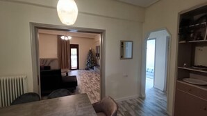 A room with a dining table, a sofa, a Christmas tree, and a radiator. - Deluxe Family Suite - Kalabaka (Kalabaka)