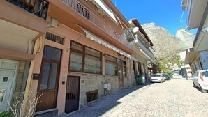 A narrow street with buildings on either side, featuring balconies and a stone facade. - Deluxe Family Suite - Kalabaka (Kalabaka)
