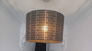 A staircase with a modern, cylindrical pendant light fixture. - The road to Wigan Pier (Wigan)