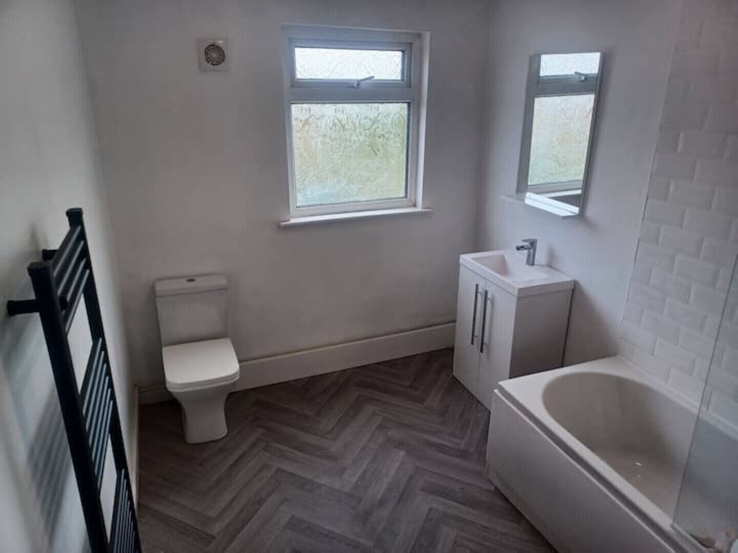 A bathroom with a toilet, sink, and bathtub.