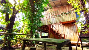 A rustic wooden structure with a balcony, surrounded by lush greenery. - Hospedaje  Reina Arriera Amazonas  (Leticia)