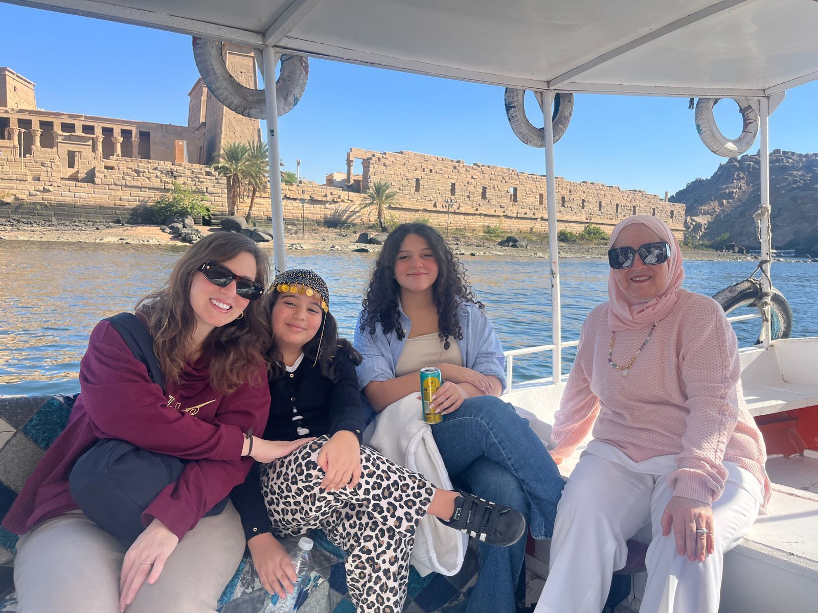A group of people on a boat with a historical building in the background.