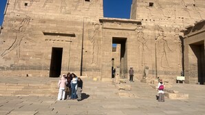 A large stone structure with hieroglyphs and statues, featuring a central doorway and steps leading up to it. - Dahab Guest House (Aswan)