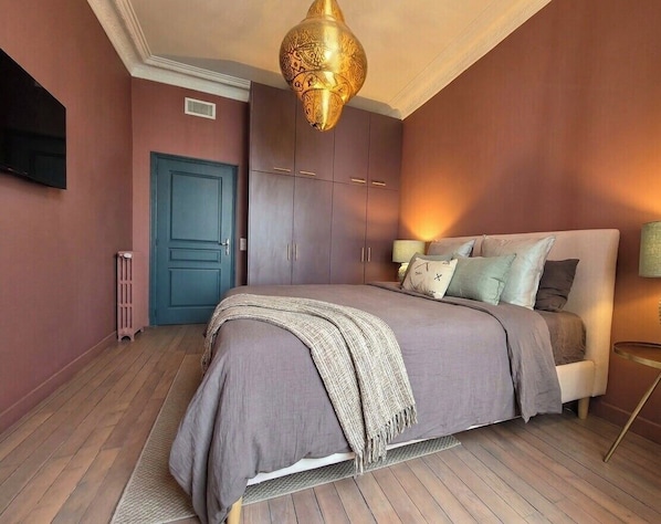 A bedroom with a bed, a blue door, and a hanging light fixture. - Close to the beach behind the famous Negresco ! (Nice)