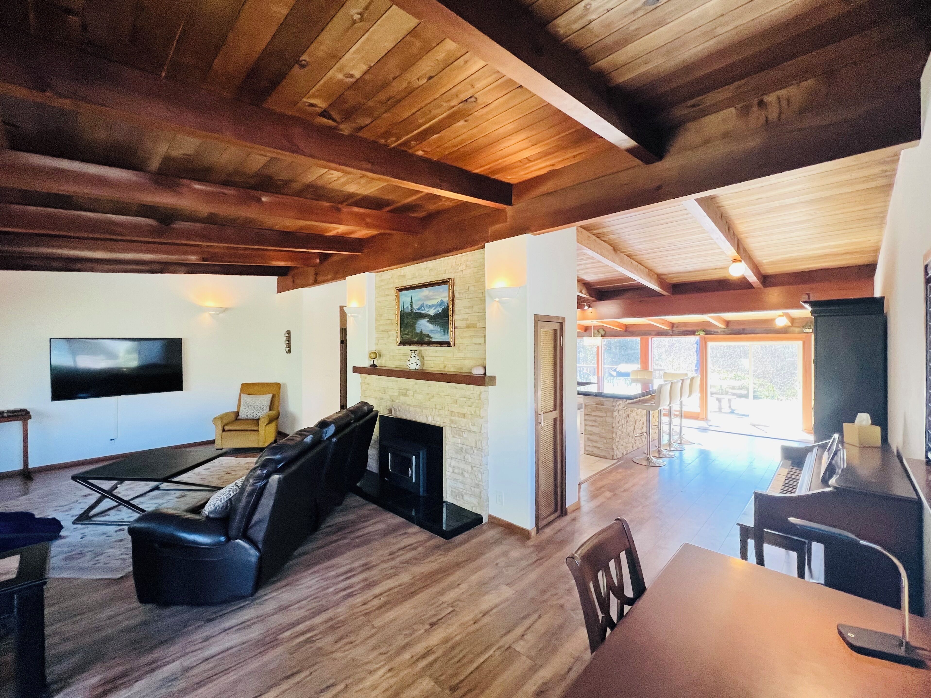 A spacious living area with a fireplace, a television, and a dining area with a piano.