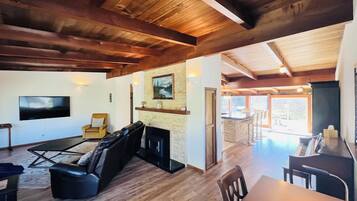 A spacious living area with a fireplace, a television, and a dining area with a piano.
