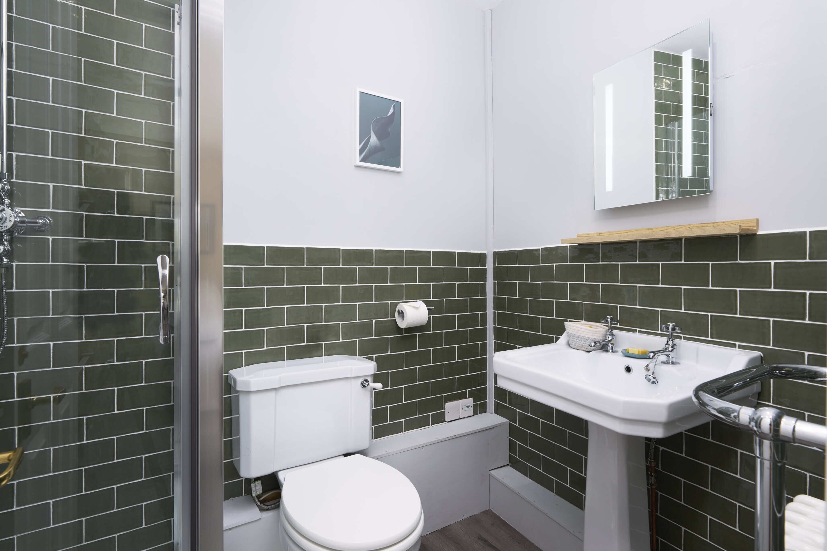 Une salle de bain avec des toilettes, un lavabo et une douche.