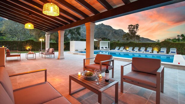 Een terras met zwembad en een berg op de achtergrond.
