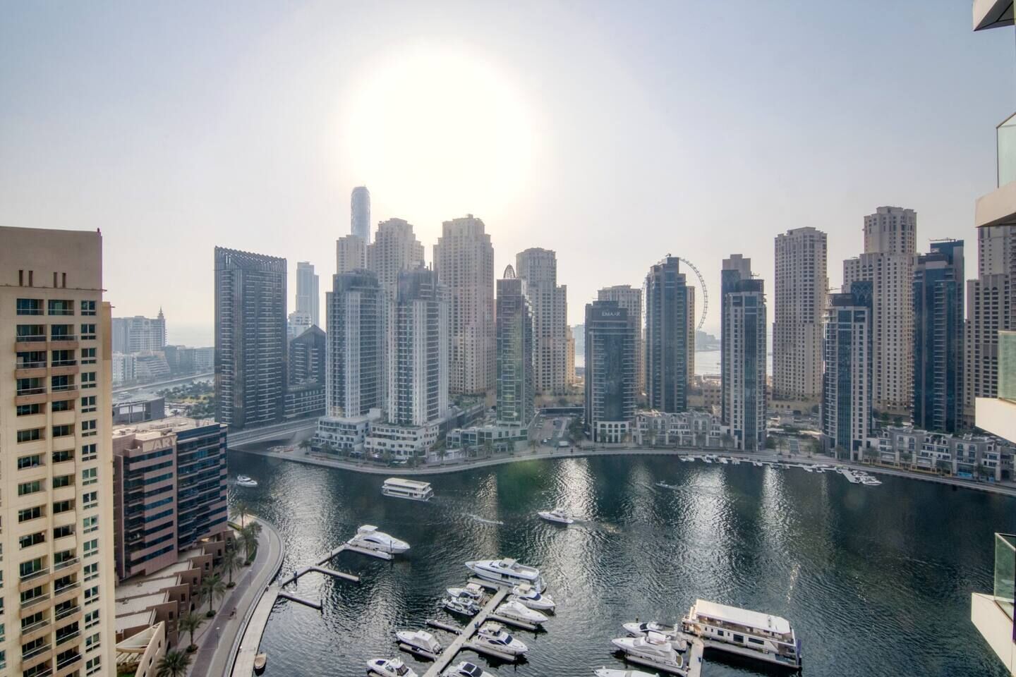 A high-rise cityscape with a marina and boats.