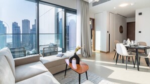 Une chambre d’hôtel moderne dotée d’un balcon, d’un coin repas et offrant une vue sur la ville.