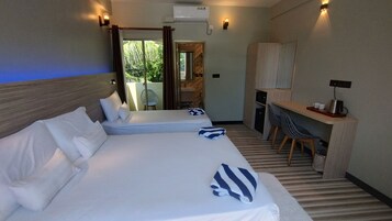 Habitación de hotel con dos camas, un escritorio y una kitchenette.