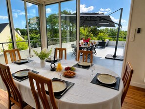 A dining area with a round table set for four, surrounded by chairs.